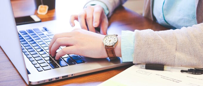 Fingers Typing on the Keyboard of the Laptop